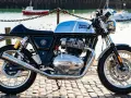 Błyszczący, chromowany rozrząd królewski Royal Enfield Continental GT 650 na tle portu.