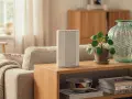 En stilren router på ett sidobord i vardagsrummet, redo för tv via mobilt bredband. En grön vas och en krukväxt ger liv åt inredningen.