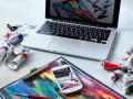 Na biurku leżą farby i laptop, na ekranie którego widać podobny obraz. Zastanawiasz się, ile zarabia grafik komputerowy?