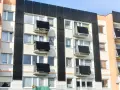 Prawdziwa historia bloku, który zaczął się przechylać po wykopach pod sąsiednią inwestycję. Widok na fasadę budynku z balkonami i oknami.
