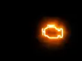 Icona luminosa arancione di un motore su sfondo nero. La spia MIL accesa indica un problema.