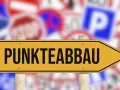 Gelbes Schild mit der Aufschrift "PUNKTEABBAU" weist den Weg. Informieren Sie sich über die fahreignungsseminar kosten, um Punkte abzubauen.