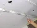 Hand spachtelt Rigipsdecke, um eine glatte Oberfläche für den Innenausbau zu schaffen.