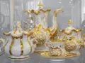 Elegancka zastawa kawowa z Muzeum Porcelany Wałbrzych, zdobiona złotem i motywami roślinnymi, zachwyca kunsztem wykonania.