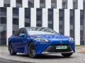 Niebieski samochód Toyota Mirai na tle nowoczesnego budynku.