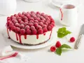 Himbeertorte mit Mascarpone, üppig belegt mit frischen Himbeeren und rotem Fruchtsirup, der über den Rand tropft.