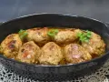 Zrazy z mięsa mielonego w sosie, udekorowane natką pietruszki, prezentują się apetycznie w czarnej brytfance.
