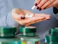 Frau nimmt Pillen, darunter 5-HTP, aus ihrer Hand.