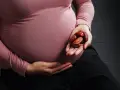 Kobieta w ciąży trzyma w dłoni garść daktyli. To naturalny sposób na wsparcie organizmu w tym wyjątkowym czasie.