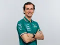 Pedro de la Rosa, con brazos cruzados, sonríe con confianza. Viste un polo verde del equipo Aston Martin Aramco.