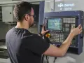 Operator CNC przy panelu sterowania. Dobra praca to wysokie operator cnc zarobki.