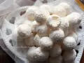 Dolci palline di cocco, morbide e profumate, adagiate su un piatto decorato con un velo di tulle.