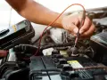 Mechanik sprawdza akumulator, szukając objawów awarii alternatora.