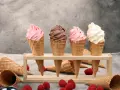 Vier Eiswaffeln mit Erdbeer-, Schoko- und Vanilleeis. Ein köstliches Gelato Rezept zum Nachmachen, mit frischen Himbeeren und Schokolade.