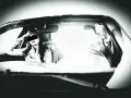 Frau im Auto, die sich die Hand ans Gesicht legt, während ein greller Blitz aufleuchtet. Ein blitzer foto, das die Szene einfängt.