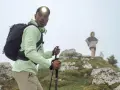 Randonneur ajustant son réglage bâton de marche, prêt à affronter la brume avec sa lampe frontale.