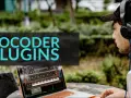 Mann mit Kopfhörern und Tätowierung am Arm arbeitet draußen an einem Laptop, auf dem Vocoder Plugins angezeigt werden.