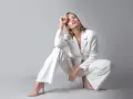 Elegancka kobieta w białym garniturze i cielistych szpilkach. Idealne buty do białego garnituru podkreślają stylizację.