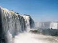 Potężne wodospady Iguazú w Argentynie, kaskady wody spadające z klifów, otoczone zielenią i spowite mgiełką.