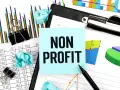 Analyzing financial reports for nonprofits. The image shows charts, graphs, and a sticky note with "NON PROFIT" written on it.