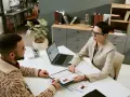 Rozmowa rekrutacyjna. Kandydat z CV w ręku pyta, czy staż z urzędu pracy wlicza się do stażu pracy. Rekruterka słucha uważnie.