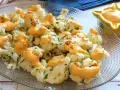Coliflor al ajillo con salsa cremosa, adornada con perejil fresco y trocitos de ajo crujiente.
