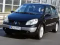 Czarny Renault Scenic 2 jedzie autostradą. Kierowca w okularach przeciwsłonecznych prowadzi auto.