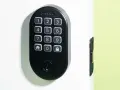 Black Schlage keypad lock on a white door, showing numbers and icons. Learn how to change door lock code for enhanced security.