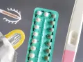 Różne rodzaje tabletek antykoncepcyjnych, wkładka domaciczna, prezerwatywa i test ciążowy.