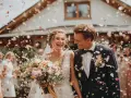 Szczęśliwa para młoda w deszczu płatków róż. Zastanawiasz się, ile kosztuje wesele?