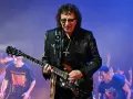 Tony Iommi, Gitarrist von Black Sabbath, spielt auf der Bühne. Im Hintergrund jubelt das Publikum.