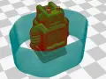 Model robota na drukarce 3D, otoczony niebieską obwódką. To pokazuje, co to adhezja, czyli przyczepność wydruku do stołu.