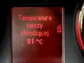 Wyświetlacz pokazuje temperaturę płynu chłodniczego: 91°C. Obok widać fragmenty wskaźników.