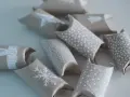 En adventskalender av toarullar, dekorerade med vita julmotiv som snöflingor och stjärnor. Perfekt för att skapa egna små överraskningar.