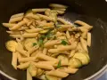 Penne con zucchine saltate e basilico fresco, un classico piatto di pasta e zucchine alla siciliana, pronto per essere gustato.