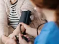 Pielęgniarka mierzy ciśnienie kobiecie w ciąży. Monitorowanie podwyższonego ciśnienia pod koniec ciąży jest kluczowe dla zdrowia mamy i dziecka.