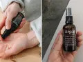 Händer applicerar arganolja ansikte från en mörk glasflaska. Oljan ger näring och lyster.