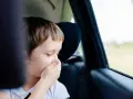 Chłopiec w samochodzie zakrywa usta ręką, być może czuje się źle. Może przydałby się cinnarizinum na chorobę lokomocyjną.