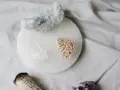 Cristales de selenita, cuarzo y amatista sobre un plato de selenita, junto a un manojo de salvia. Guía para saber como limpiar la selenita.