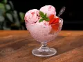 Ljuvlig jordgubbsglass utan glassmaskin i en skål, dekorerad med färska jordgubbar och mynta. Perfekt sommardessert!