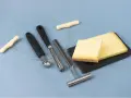 Des morceaux de fromage, des outils pour le découper et une ficelle. L'origine du fromage la dent du chat est un mystère savoureux.