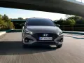 Szary Hyundai i30 1.4 benzyna pędzi po drodze pod mostem, otoczony zielenią.