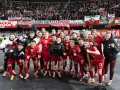 Radosna me grupa polska w czerwonych strojach świętuje z kibicami.