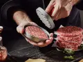 Frische burger patties werden mit einem Patty-Former geformt. Ein Stapel fertiger Patties liegt daneben.