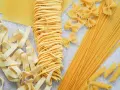 Różne rodzaje suchego makaronu: tagliatelle, farfalle, spaghetti, penne i płaty lasagne. Zastanawiasz się, ile waży makaron po ugotowaniu vs suchy?