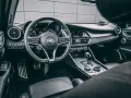 Wnętrze luksusowego samochodu Alfa Romeo. Kierownica, deska rozdzielcza i dźwignia zmiany biegów. Ta fotografia samochodowa oddaje styl i komfort.