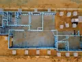 Estructura metálica de una casa en construcción. Se aprecian materiales apilados, listos para el montaje. El precio de hacer un sótano puede variar.