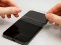 Delikatnie odklejanie folii ochronnej od ekranu telefonu. Dowiedz się, jak zdjąć szkło hartowane bez problemów.