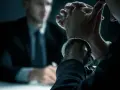 Zakuci w kajdankach, przesłuchiwany mężczyzna. Czy prace społeczne można zamienić na grzywnę?