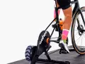 Cyclist training indoors on a bike with a Wahoo trainer, experiencing adjustable bike resistance for a challenging workout.